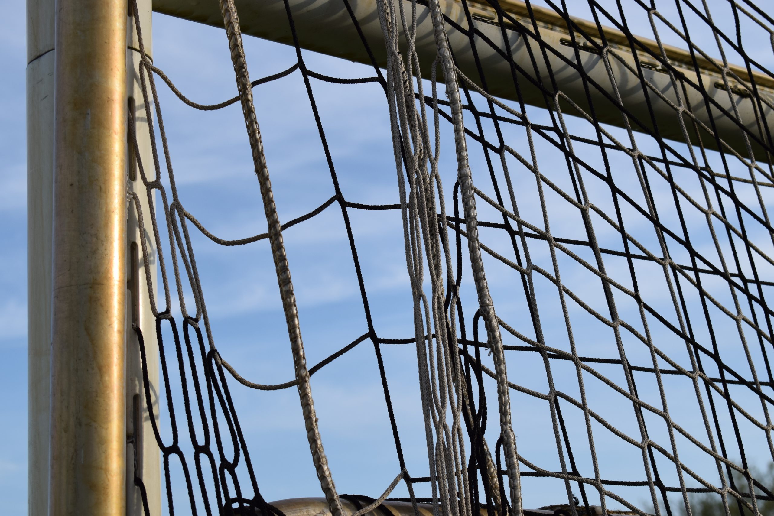 Ein Netz hängt in einem Fußballtor. Zu sehen ist der obere rechte Torwinkel im Anschnitt.