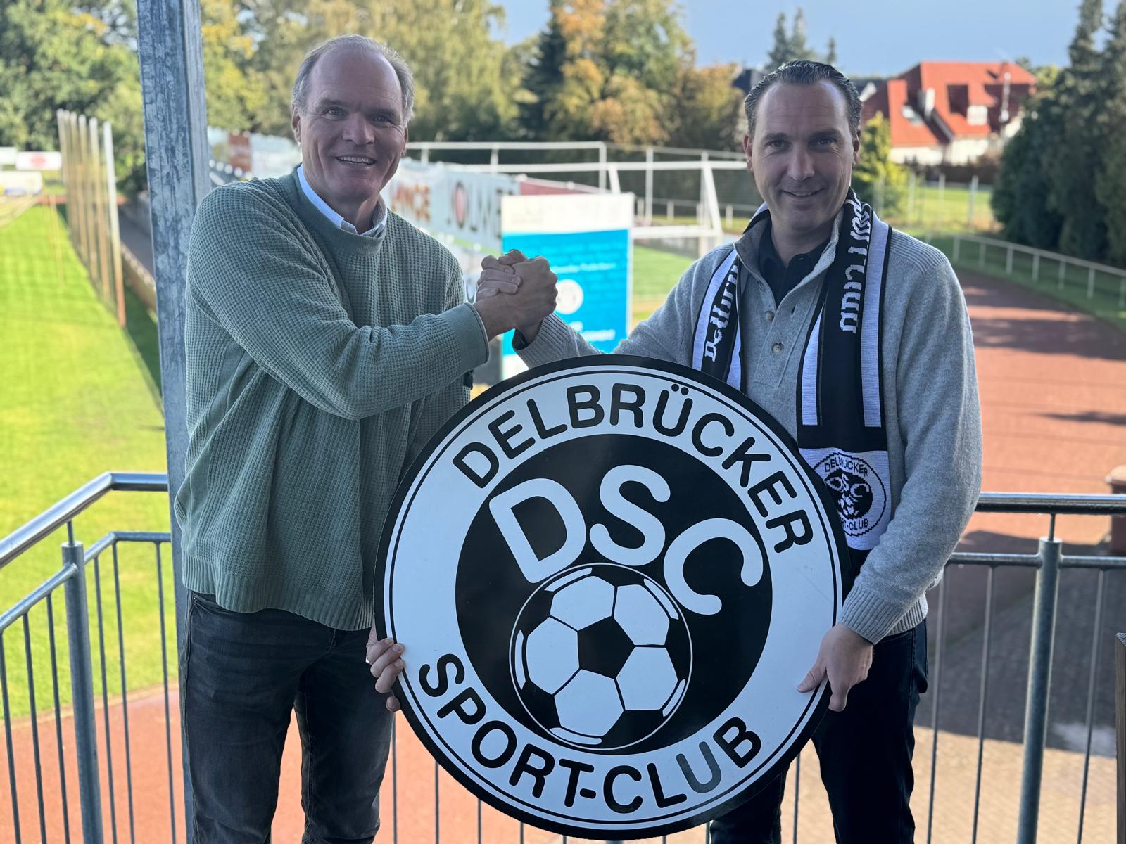 Markus Epping links und Elmar Westermeyer rechts besiegeln die Kooperationsvereinbarung zwischen dem Delbrücker SC und der Epping Green Energy GmbH